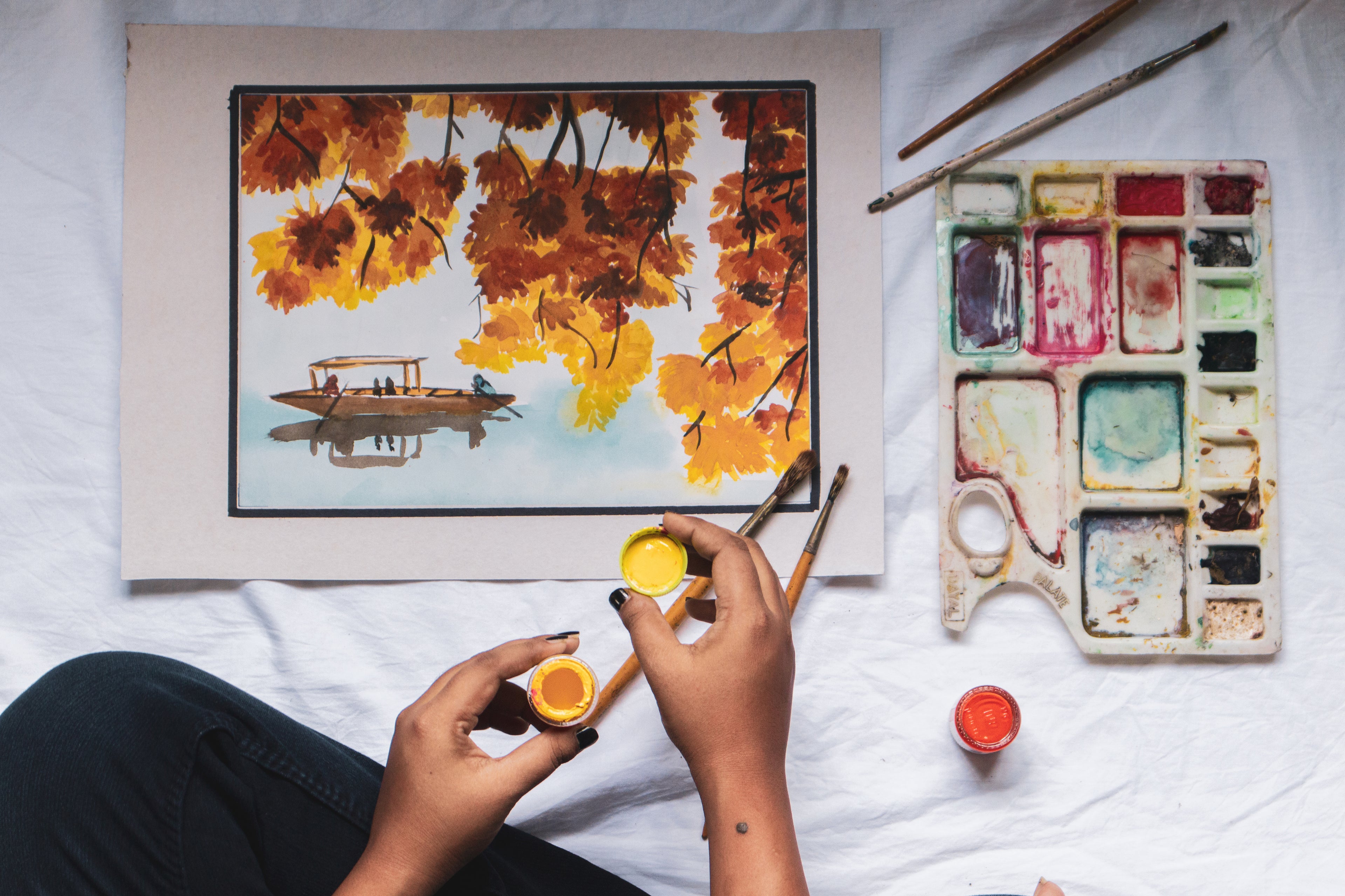 painting of autumn leaves and small kayak